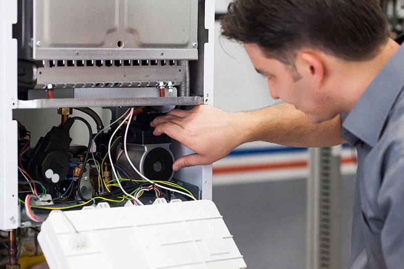 HVAC technician performing maintenance on heat pump.