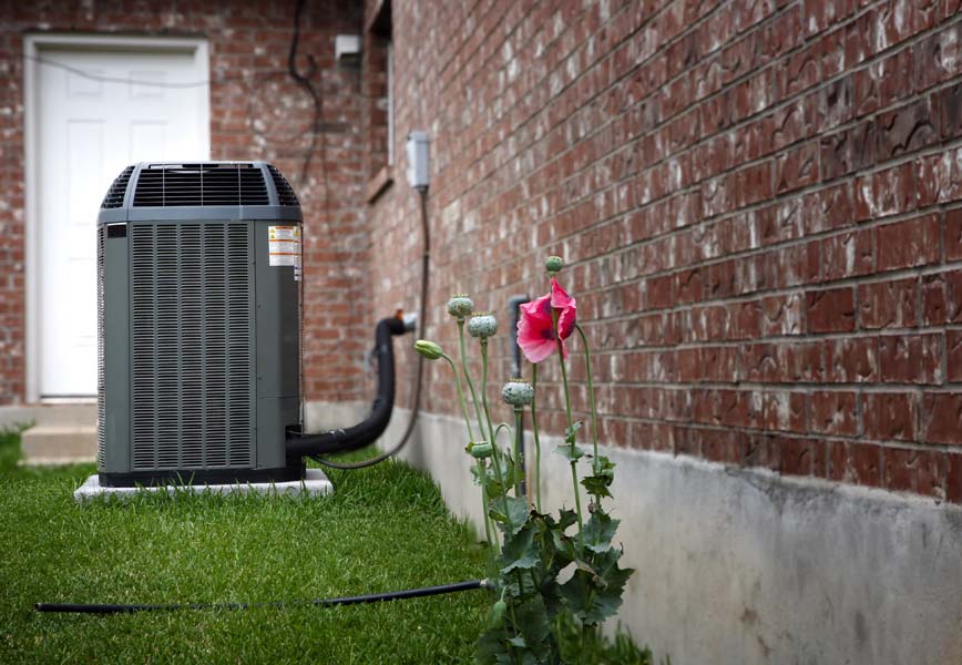 AC unit hooked up to building in backyard of home